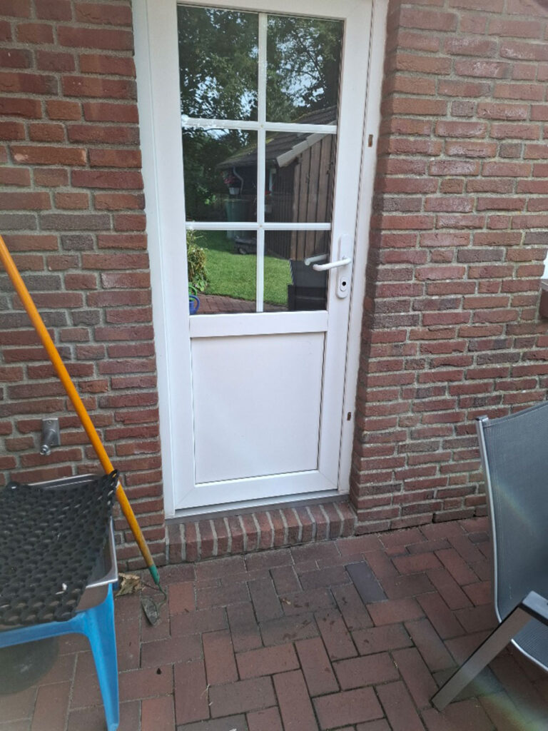 Vorher-Ansicht einer Nebeneingangstür mit hoher Schwelle.