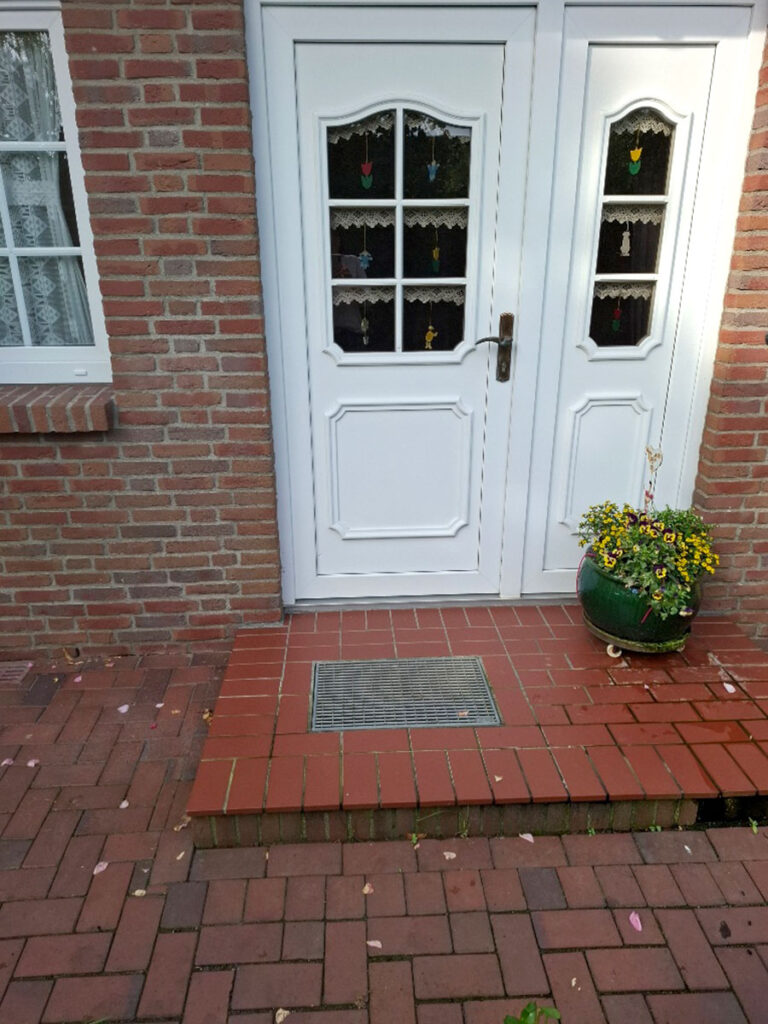 Vorher-Zustand eines Haupteingangs mit Stufen und Podest.