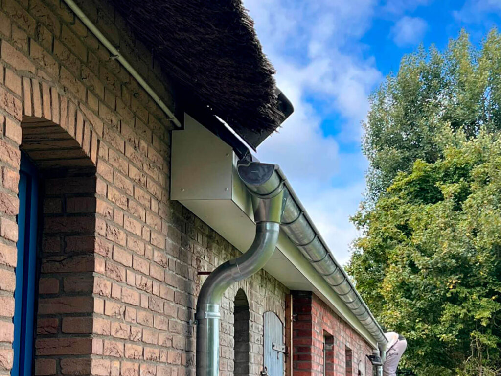 Nachher-Ansicht einer sanierten Dachrinne an einem Gebäude.