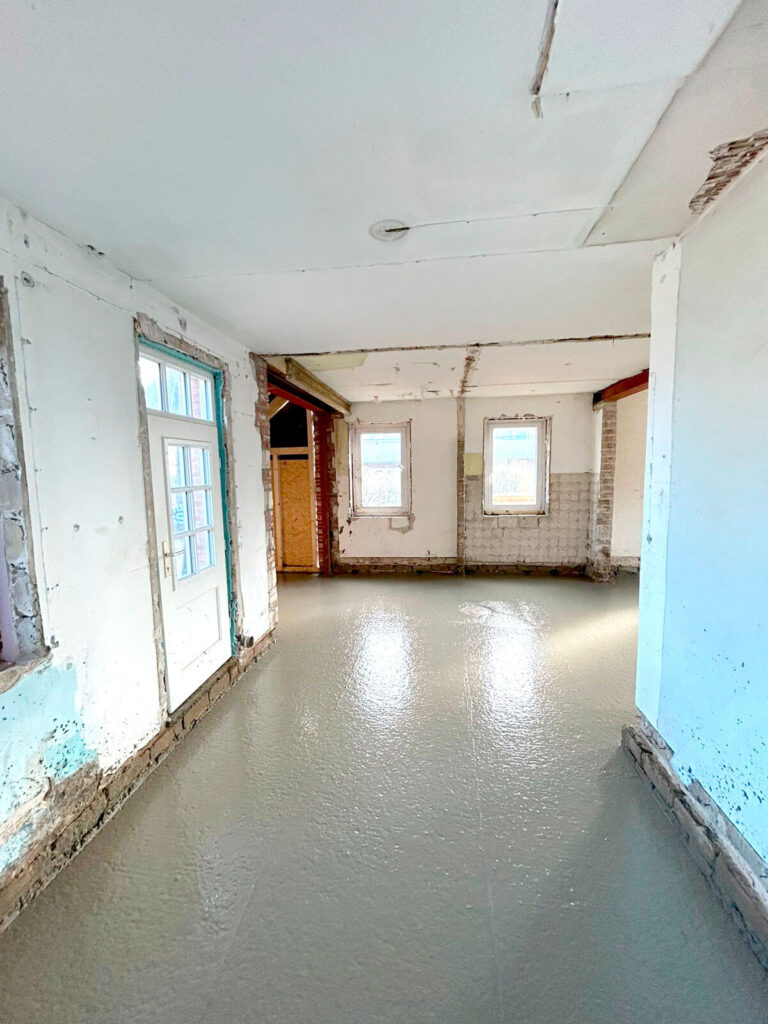 Fortschritt der Sanierung: Maurerarbeiten an der Fassade eines Hauses.